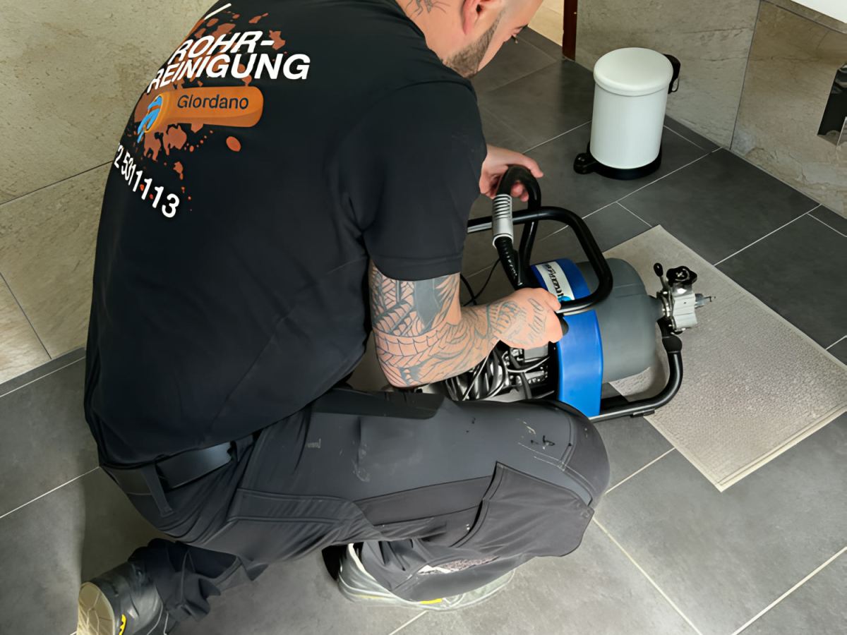 Rohrreinigung mit motorbetriebener Spirale im Bad