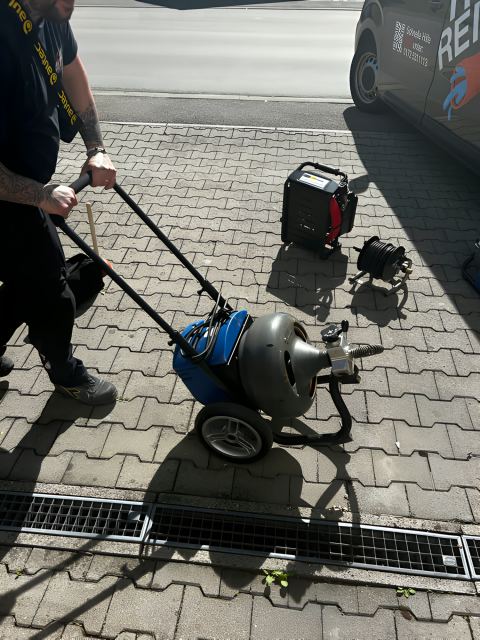 Spiralmaschine an einer Entwässerungsrinne in der Einfahrt